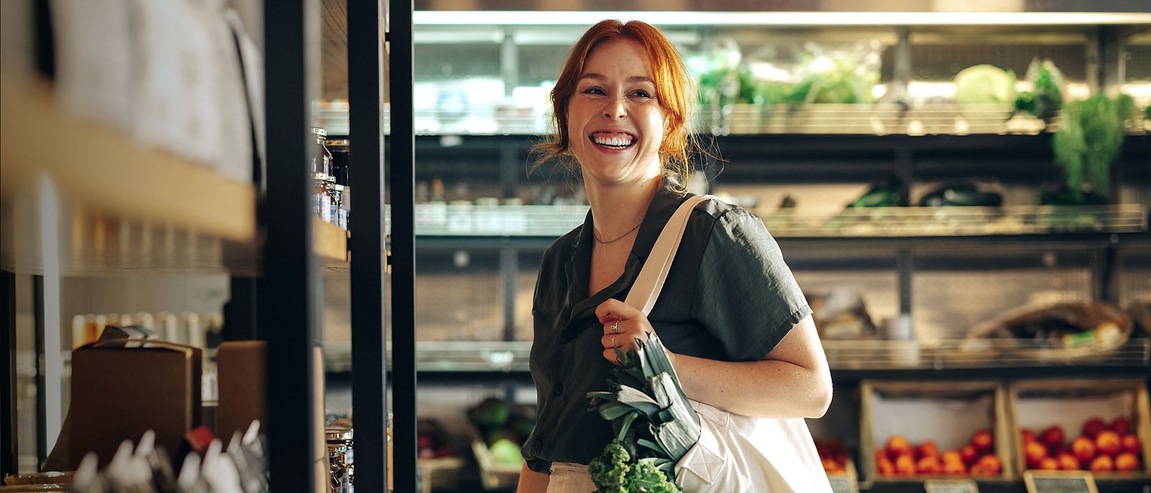 Woman with a bag in a supermarket with fresh vegetables