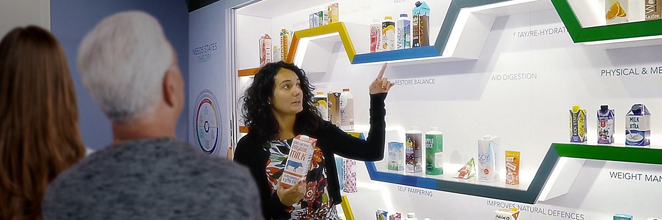 Mujer con un envase de cartón en la sala de talleres del CIC